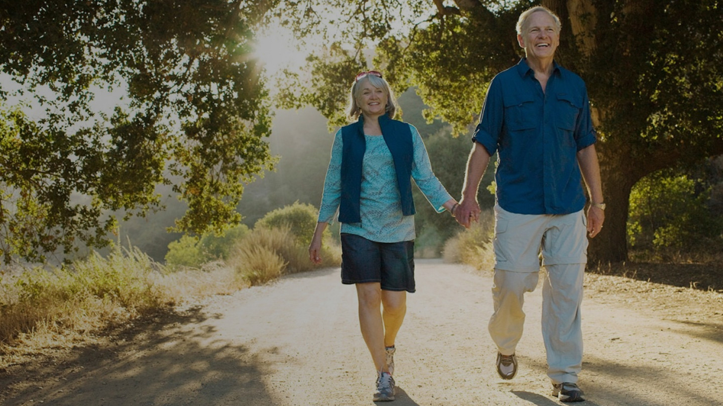 Older couple walking holding hands